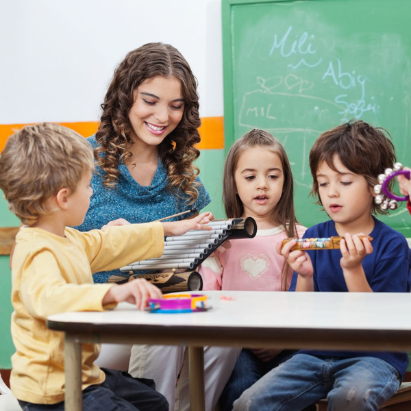 A diverse group of happy toddlers are sitting on a colorful rug, playing various musical instruments together in a bright room.