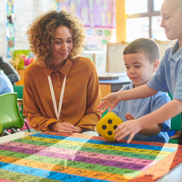 teacher playing a game with two young kids. 