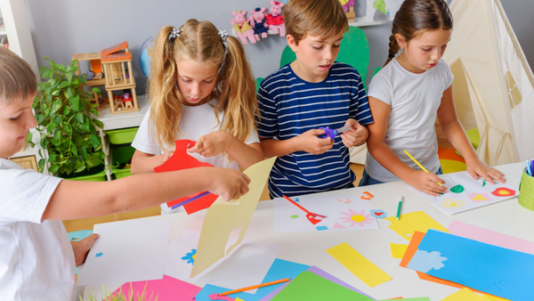 Children at daycare drawing, painting, and cutting papers