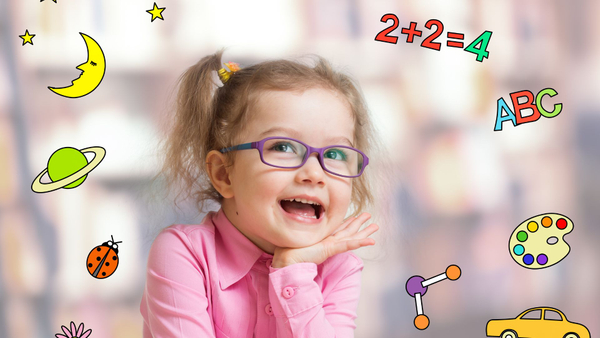 Little girl smiling and surrounded by cute education-themed graphics