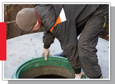 Image of a man opening a man hole cover