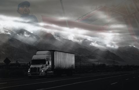 black and white semi truck with a semi driver faded in the background