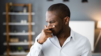 man with hand to nose, bad smell