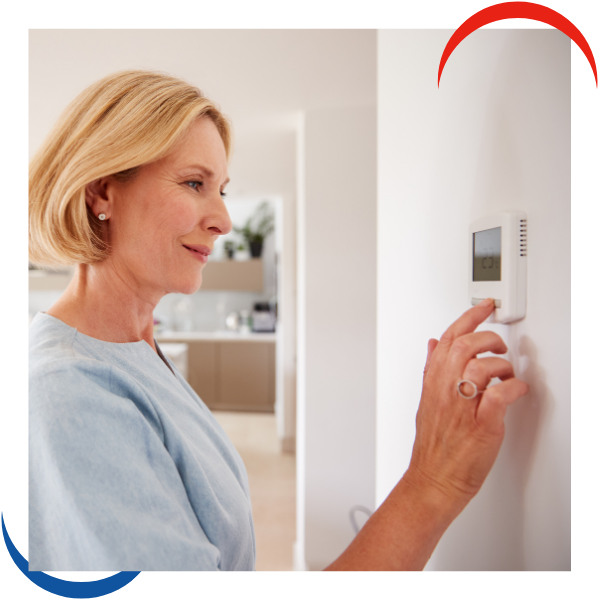 woman adjusting thermostat woman adjusting thermostat