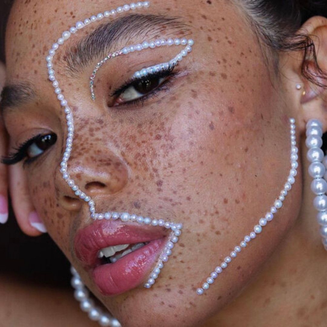 photo of a woman with lots of freckles and pearls on her face