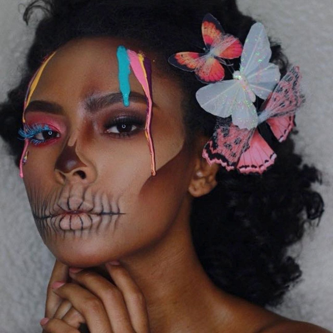 photo of woman with colorful makeup and butterflies in her hair