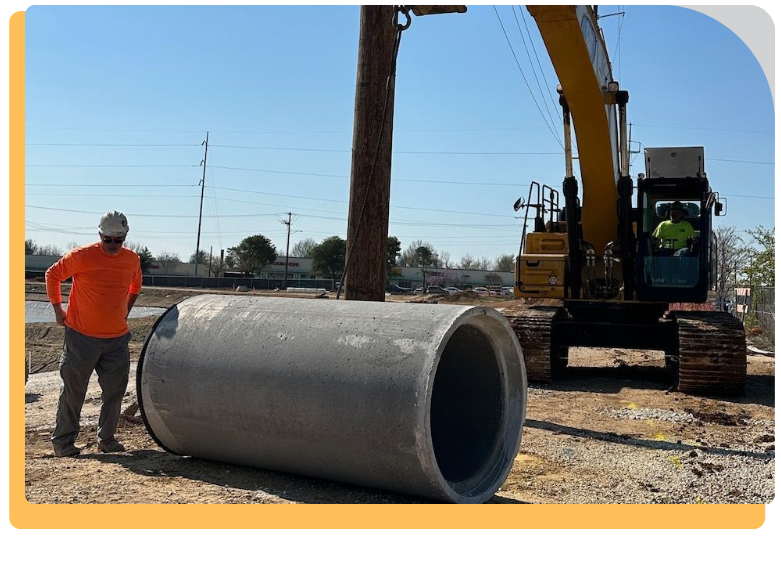 man standing next to drainage pipe with a bulldozer behind them