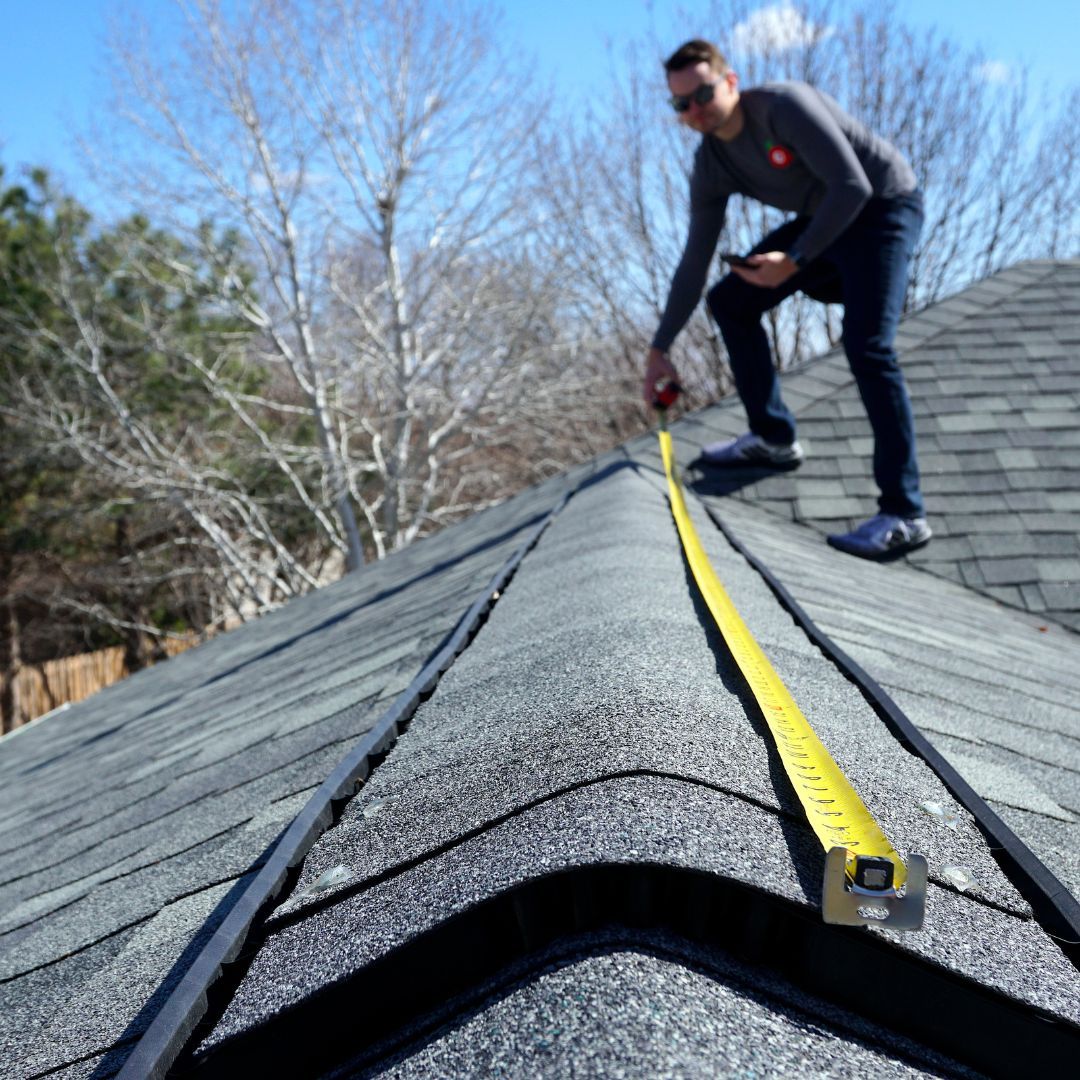 man measuring roof