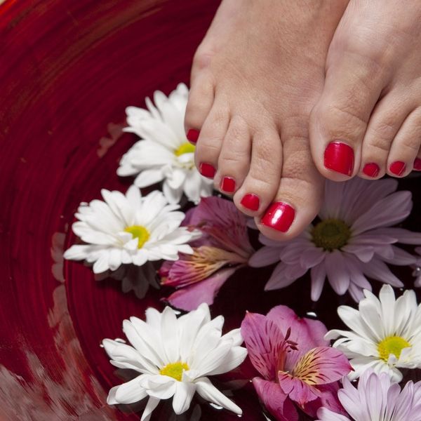 Relaxed feet in flower petals and water