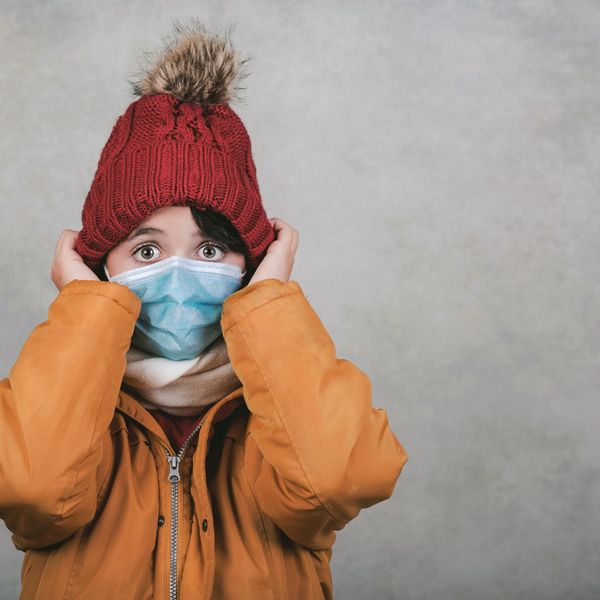 kid in winter coat wearing basic mask