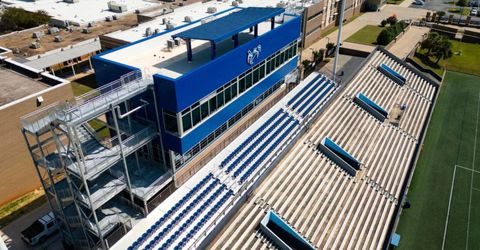 Stadium seating with blue press box and stair structure