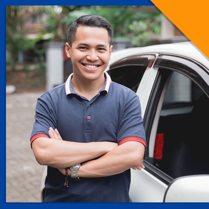 man smiling at his car