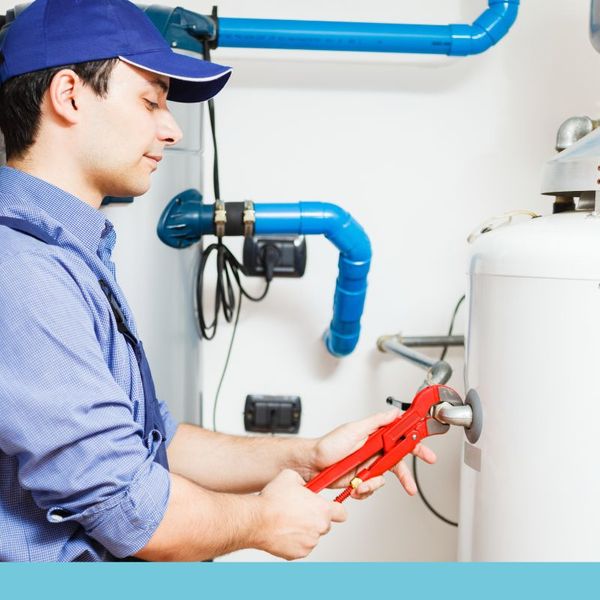 Plumber tightening a water boiler