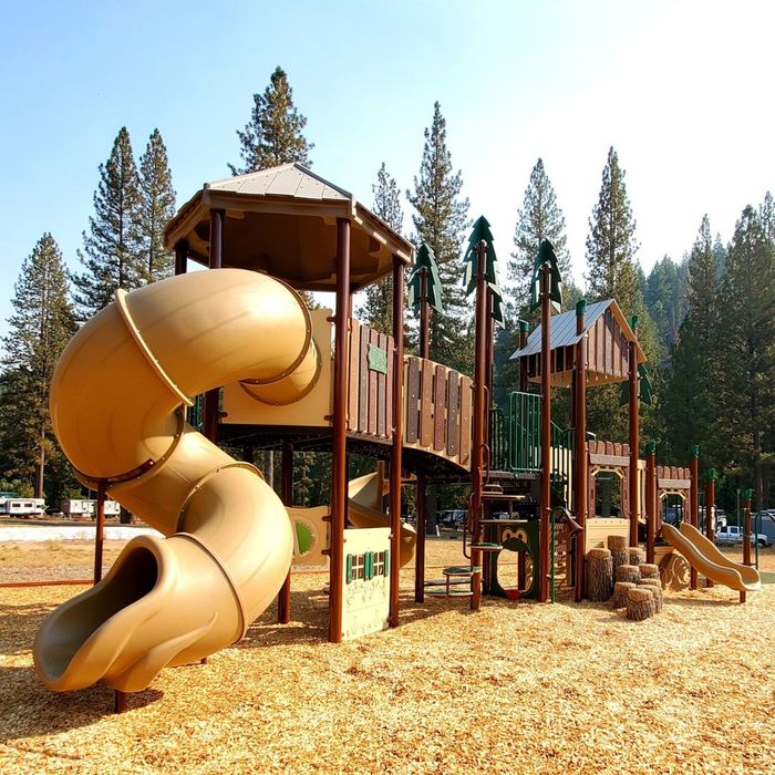 A large, nature-themed playground set in a wooded area. A large, nature-themed playground set in a wooded area.