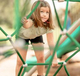girl climbing ropes on playground girl climbing ropes on playground