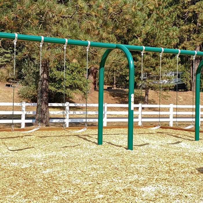 A set of swings on a playground. A set of swings on a playground.