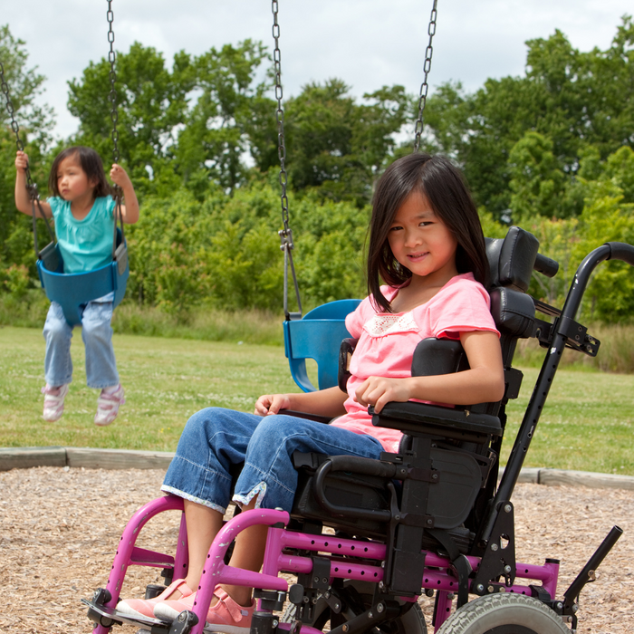 Girl in a wheelchair on a playground.