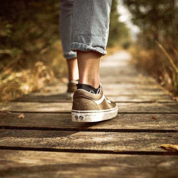 person with vans walking on boardwalk