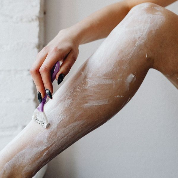 woman shaving her legs