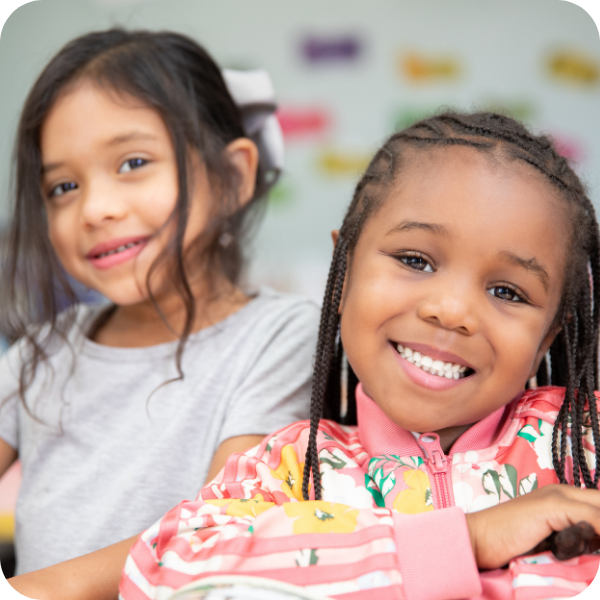 Two girls smiling next to each other
