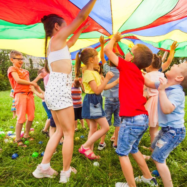 Children playing under a large umbrella