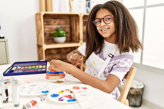 African american girl smiling confident drawing ceramic at art school.png