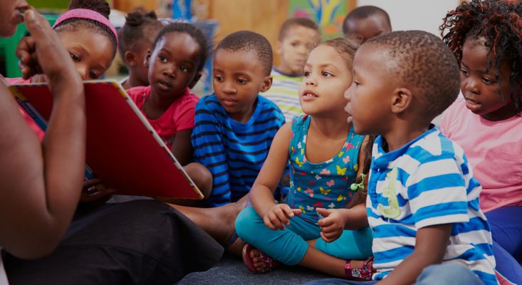 preschool kids listening to a teacher read