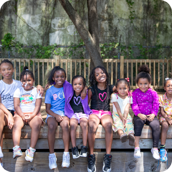 Group of younger kids smiling outside