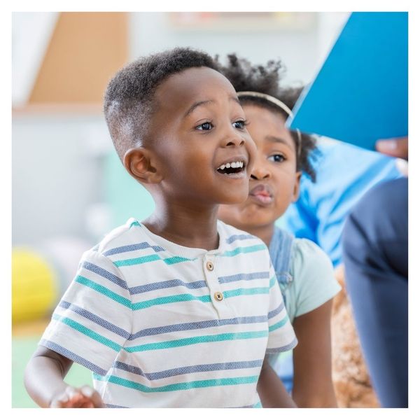 smiling preschool boy listening to a book