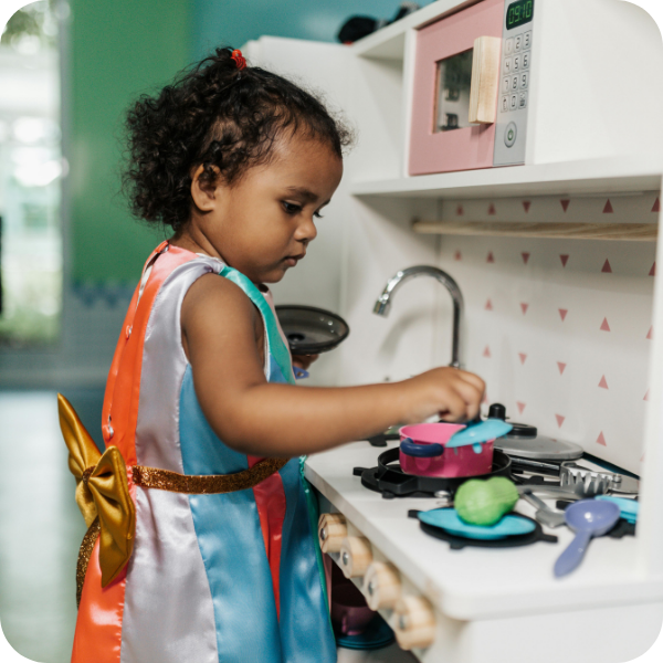 little girl playing in play kitchen