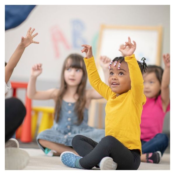 little girl raising hands above her head