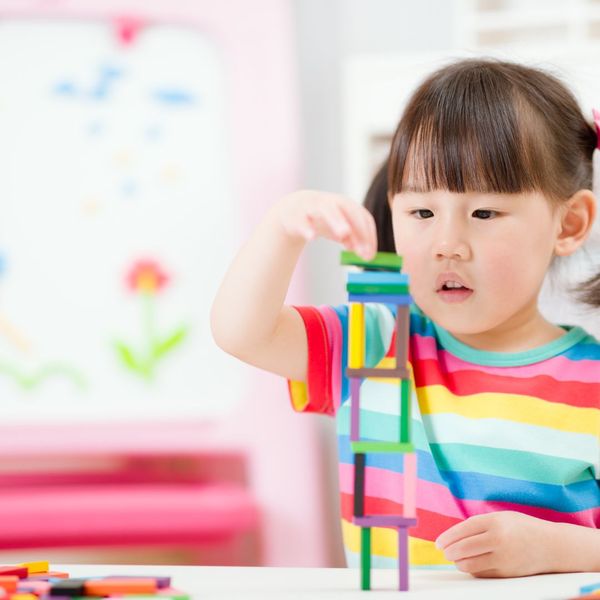A preschool girl plays with blocks