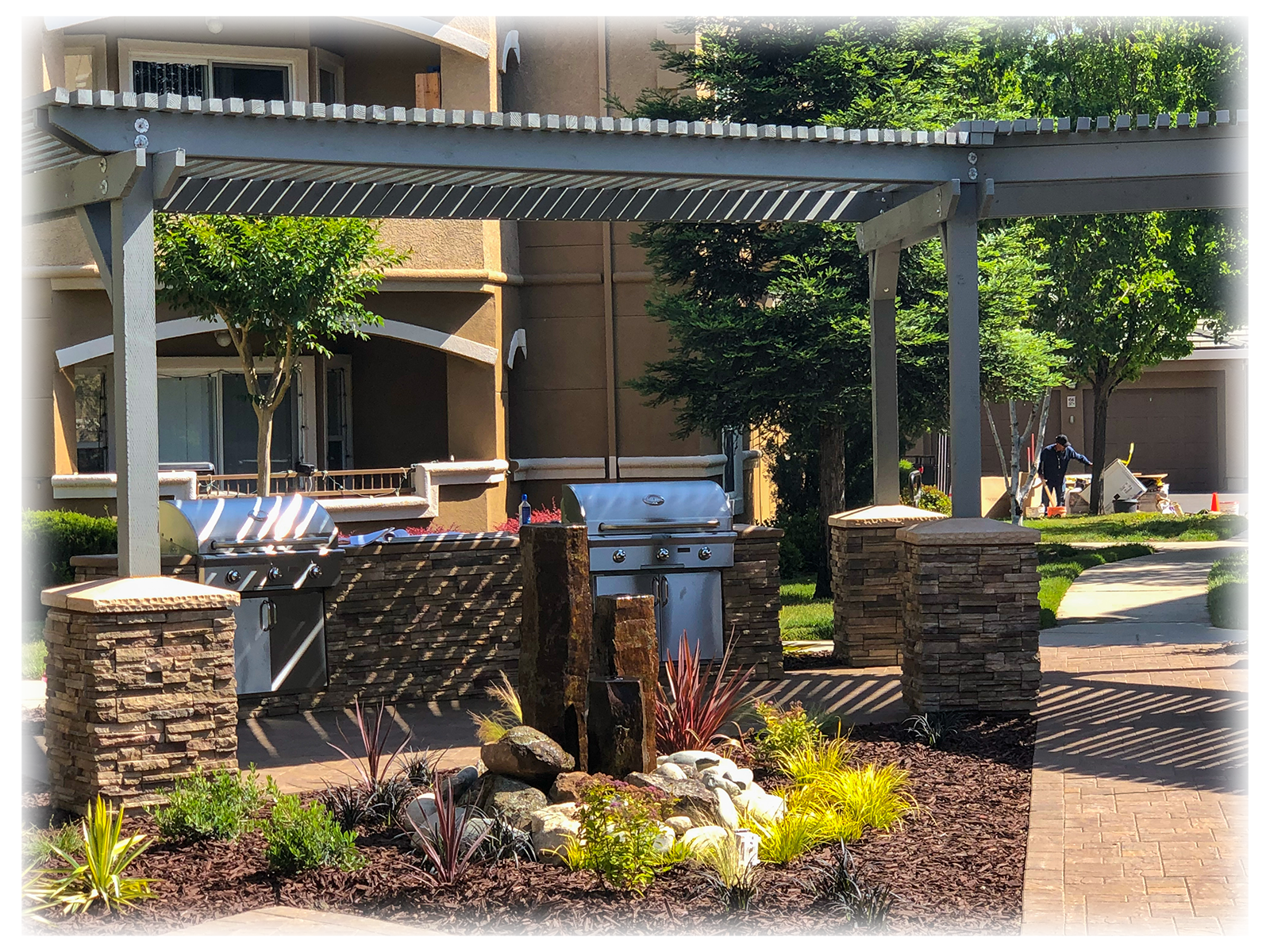 big house with barbecue setup infront in addition to plants and patio all over Landscape