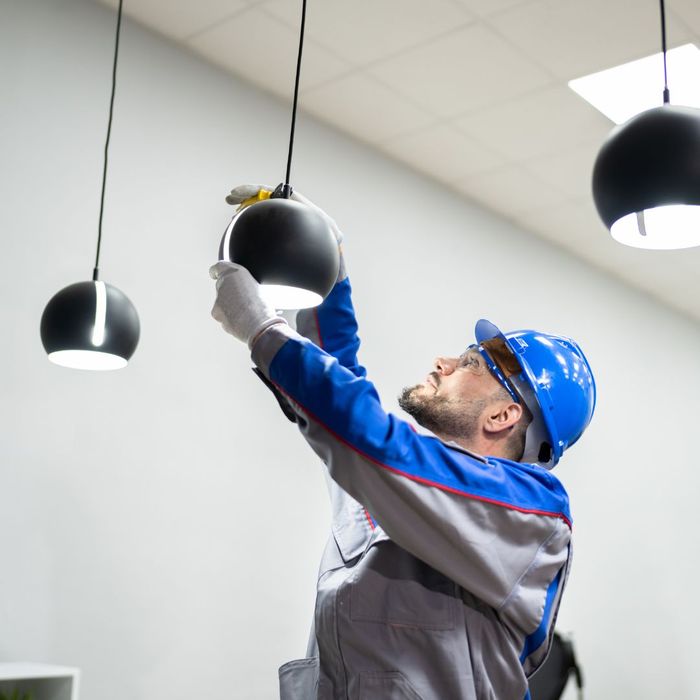 person in hard hat installing a lightbulb