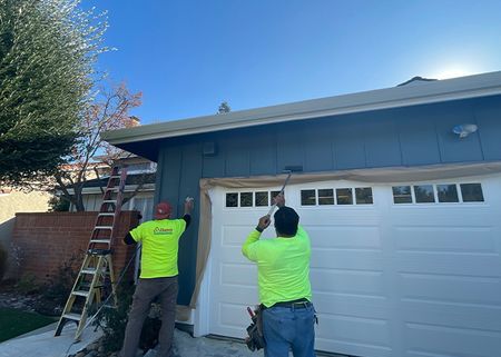 workers painting a garage exterior