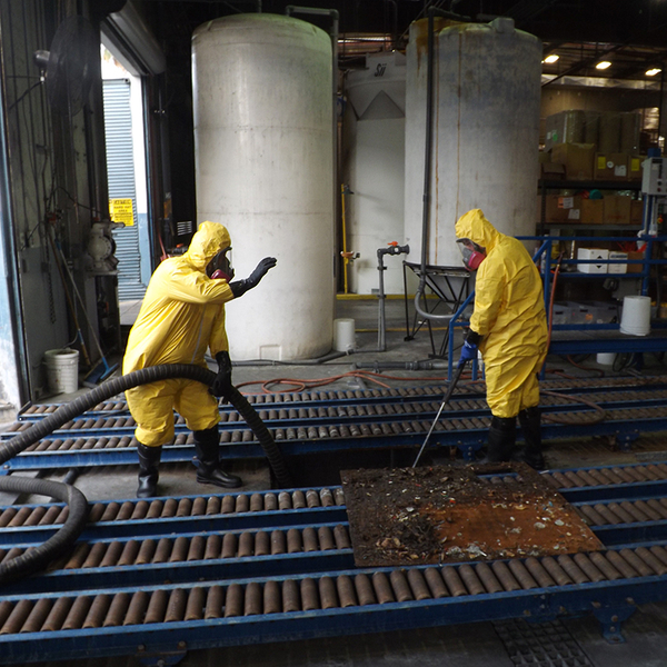 Two hazmat workers in a factory