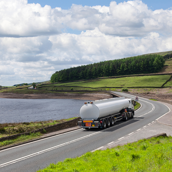 tanker truck driving through pastoral landscape