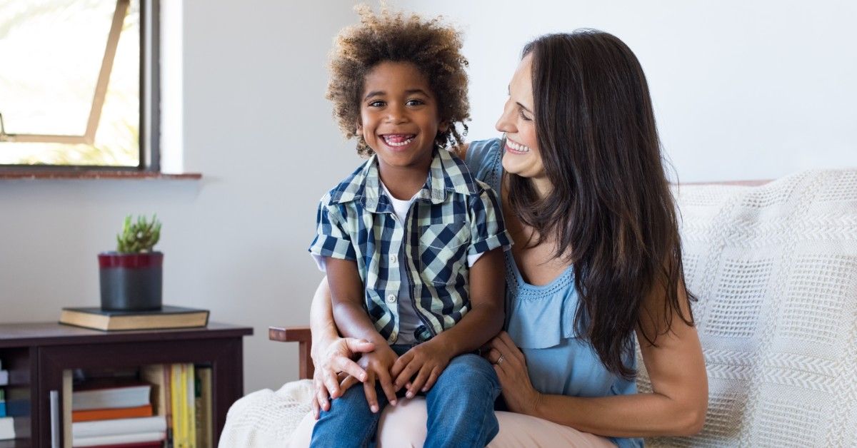 woman with child on her lap laughing together in home