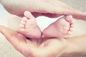 baby feet between parent's hands