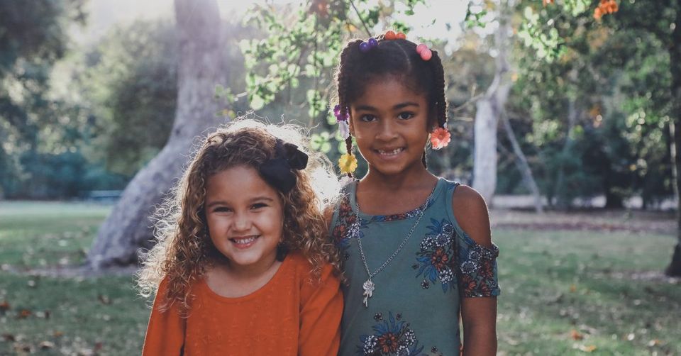 two you girls smiling in a park