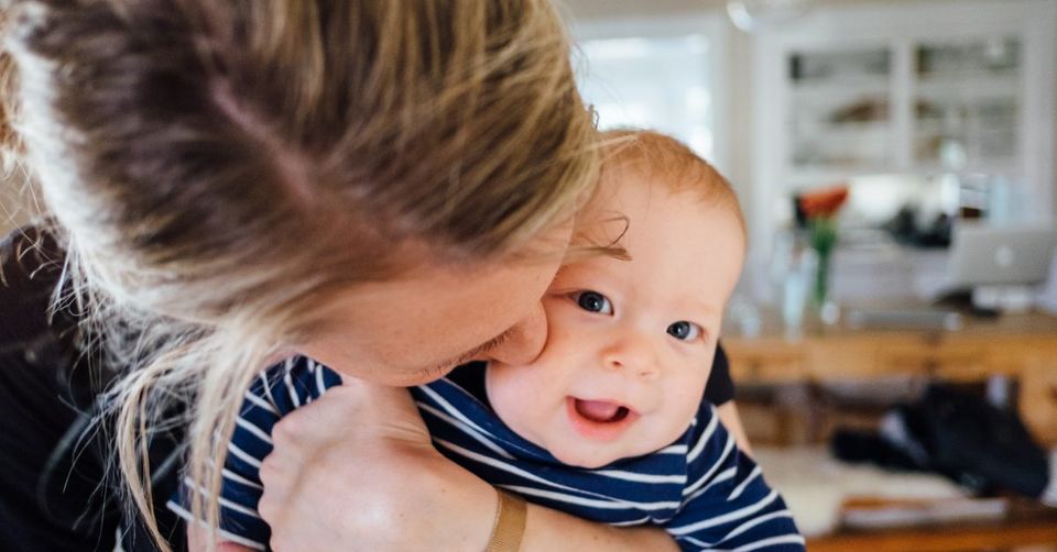 Mother kissing her happy baby