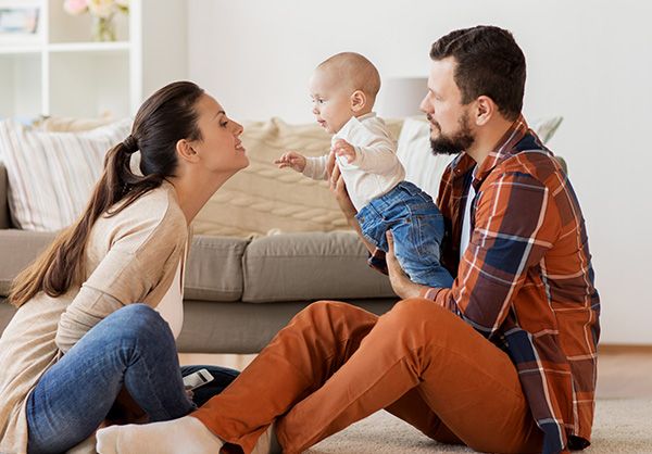 couple playing with baby in living room