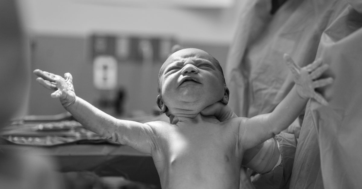 newborn baby being held by doctor