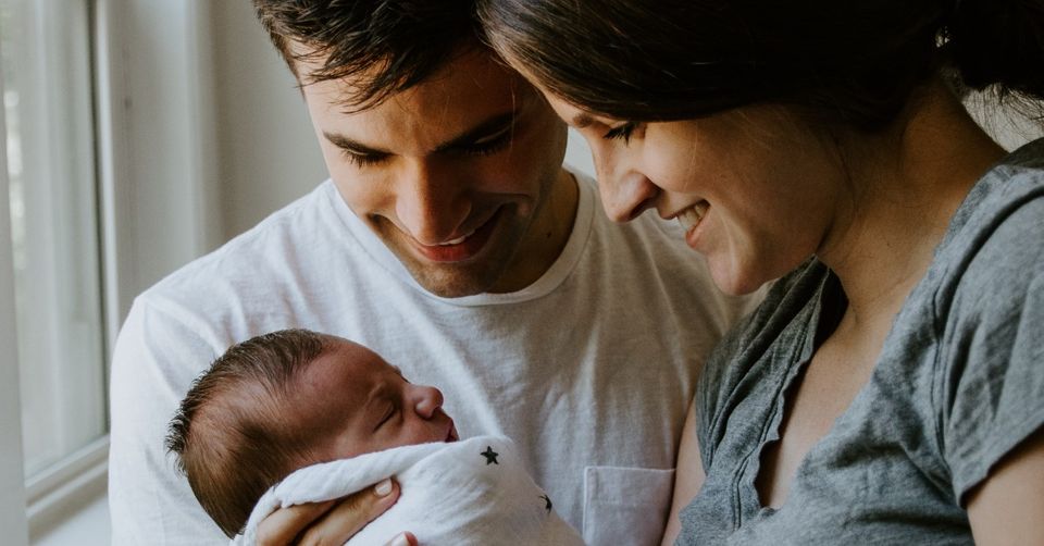 couple holding newborn baby together