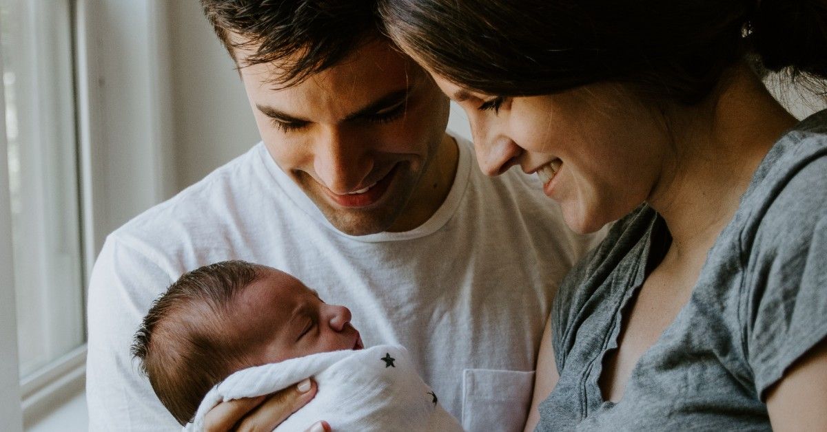 couple holding newborn baby together