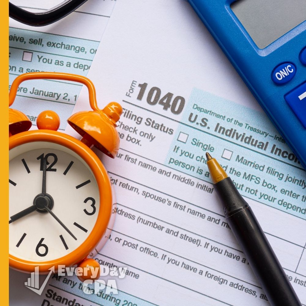 Clock, pen, and calculator on top of a 1040 form
