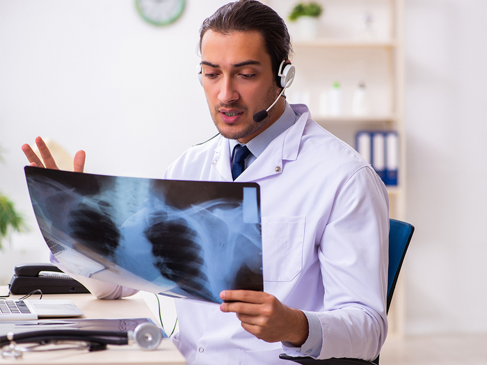 Male doctor examining an X-ray of the neck area.