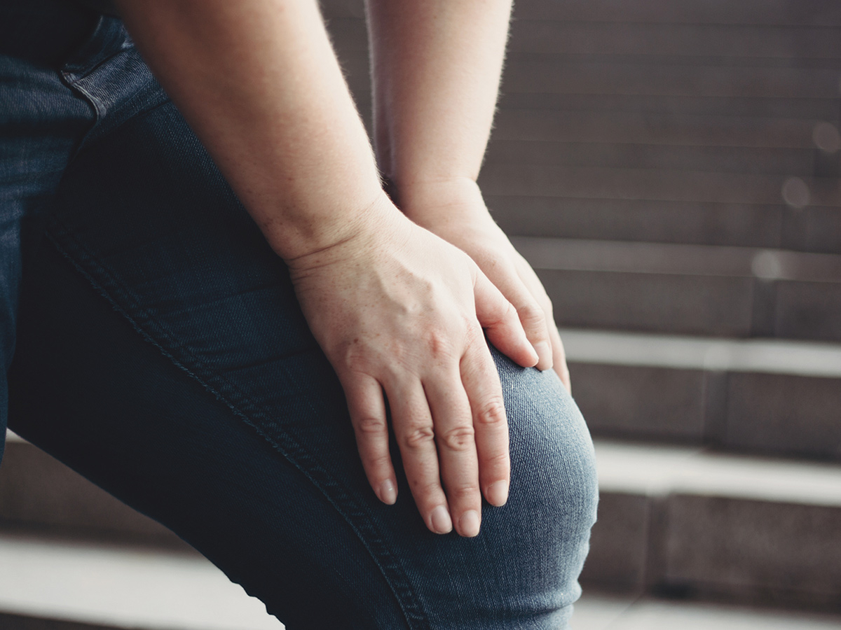 Image of a person clutching their injured knee. Image of a person clutching their injured knee.