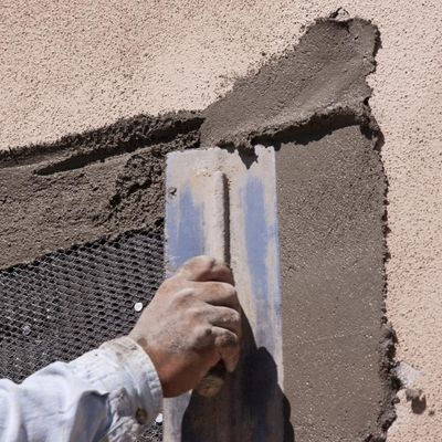 Man applying stucco to the exterior of a home