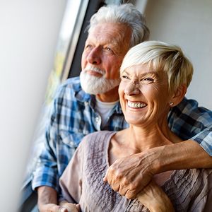 happy elderly couple looking out window